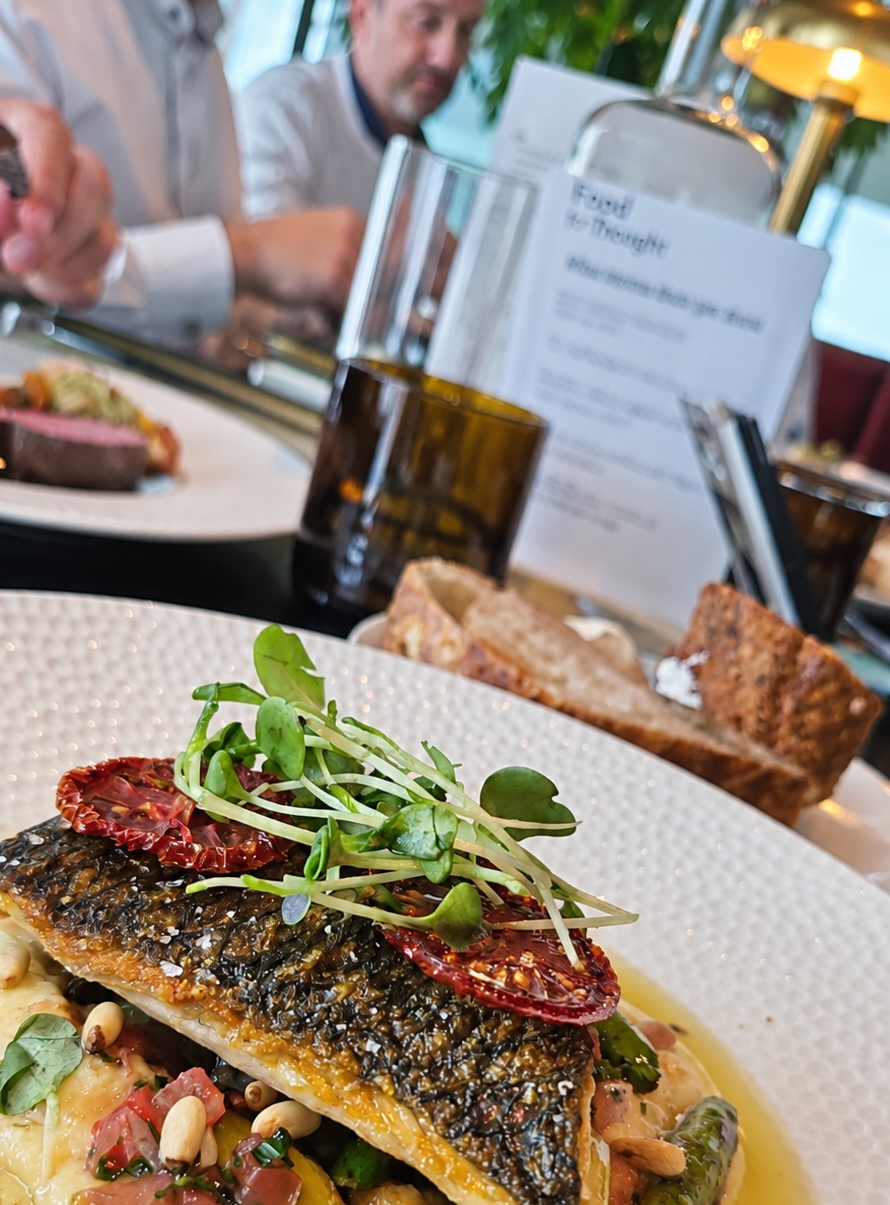 A plated dish with the Food for Thought programme card at MOON Amsterdam